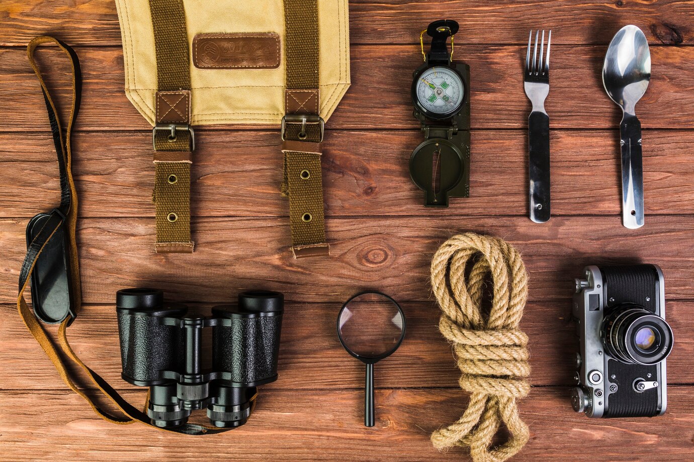 high-angle-view-camping-equipments-wooden-desk_23-2147842637